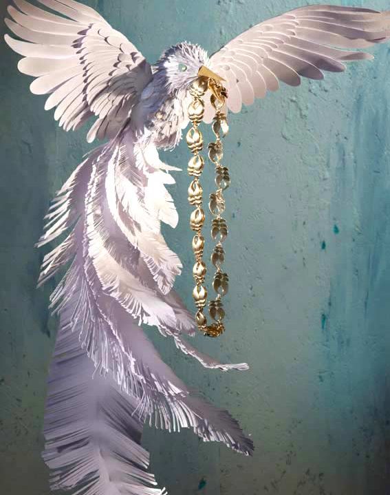 kunstvoller Papiervogel präsentiert Schmuck.