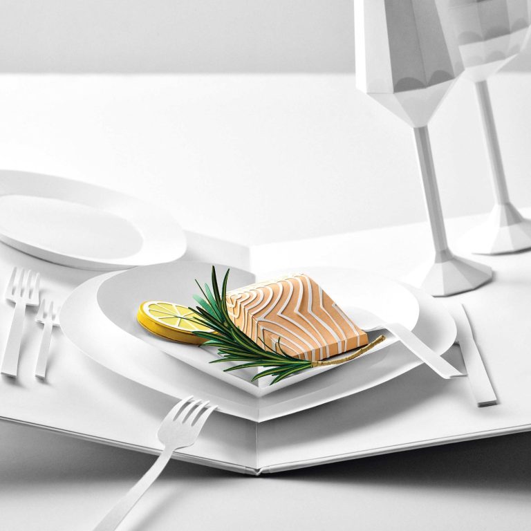 Tischszene aus Papier mit einem Teller mit gegrilltem Lachs, Zitronenscheibe und Rosmarin.