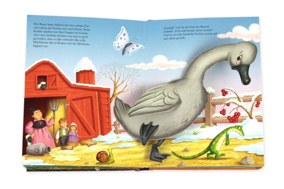 Eine große graue Gans vor einem roten Stall mit Figuren und einer grünen Echse.