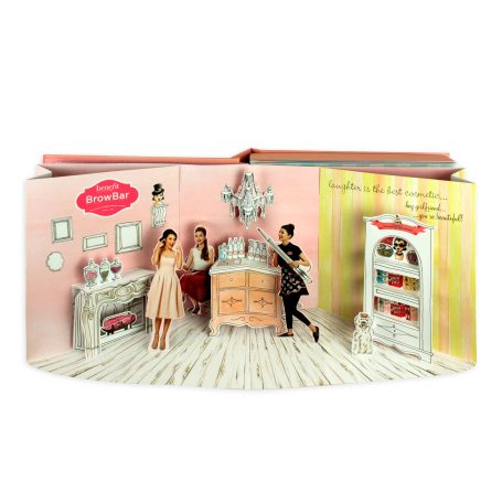 Eine Papierszene in einem Pop up Buch mit zwei Figuren und elegante Einrichtung.